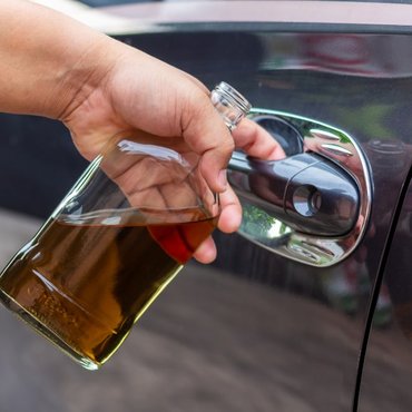 drunk-driver-holding-whiskey-bottle